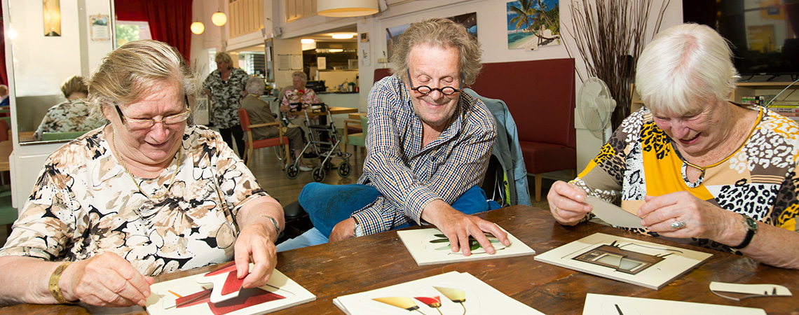 Op de foto ziet u drie senioren met Alzheimer/dementie spelen met speciale puzzels voor mensen met gevorderde dementie. Deze speciale puzzels zijn gekocht bij Spelplus: spellen voor ouderen. Duidelijk zichtbaar is dat puzzelen ook voor mensen met dementie een erg leuke bezigheid is.